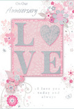 This anniversary card is captured as a gentle celebration of enduring romance, the palette bathed in soft pastel pinks, muted mauves, and cool silvery greys that echo a quiet evening sky over Shooter's Hill. At its heart, the word LOVE is beautifully displayed in softly raised glitter, each letter outlined with a delicate shimmer. The letter O is transformed into a sparkling heart, textured with silver highlights that give it both visual depth and a distinctly tactile feel, inviting fingers to trace its outline. Surrounding this focal word, clusters of graceful blooms in blush, rose, and dusty mauve unfold with an almost watercolour softness, their edges feathered and blurred as if painted in a single, careful breath. The fine, flowing lines of stems and vines curve and loop around the lettering, reminiscent of a romantic English spring garden or the calm, green pockets near Castle Wood. Tiny details-spiralling flourishes, scattered petals, and a few subtly sketched butterflies-add a sense of movement and light whimsy, like petals tumbling gently from an anniversary bouquet as it's set down on a kitchen table in Shooter's Hill. The phrases On Our Anniversary and I love you today and always appear in a graceful, understated script that harmonises with the artwork rather than overpowering it. The overall design feels intimate and sincere, like a quiet whisper between partners who have walked many years together. It conveys a sense of occasion while remaining soft and heartfelt, much like a carefully chosen arrangement ordered for local delivery to celebrate a shared journey in Shooter's Hill.
